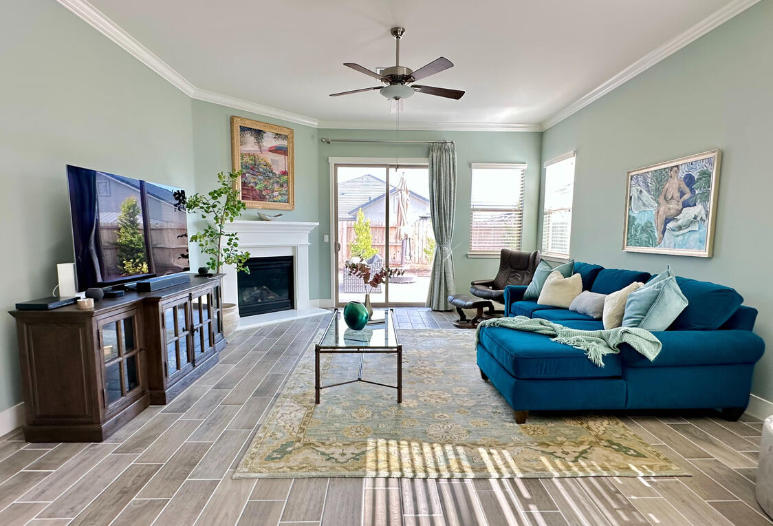 Living with sofa facing TV media thats on top of media console with rectangle coffee table